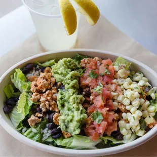 a bowl of salad and a drink