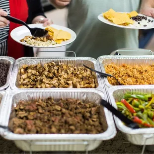 a group of people holding plates of food