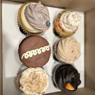 Beautiful cupcakes! (From top right: confetti rainbow chip, Churro Cupcake, orange chocolate, apple spice, ding dong, and blueberry lemon)