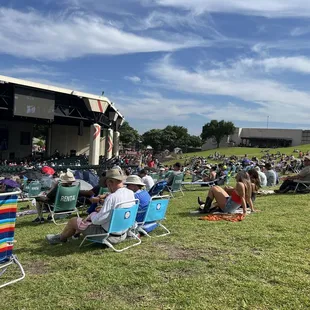 a crowd of people sitting in lawn chairs