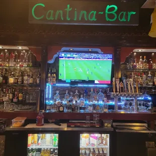 a bar with a television and drinks
