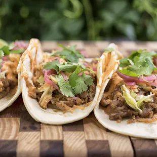 three tacos on a cutting board