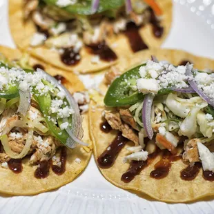 three tacos on a white plate
