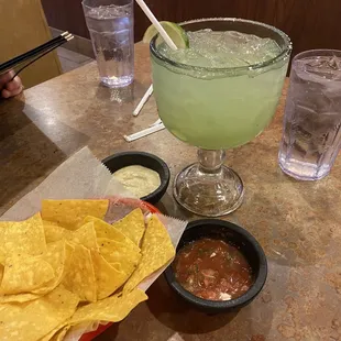Salsa n crema with chips and a classic margarita and m the rocks.