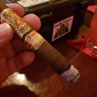 a hand holding a cigar