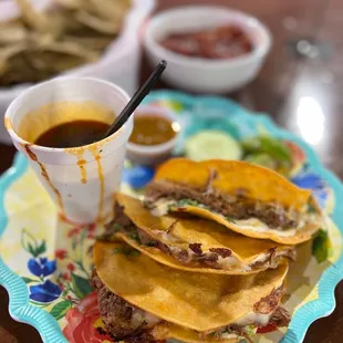 a plate of tacos and a cup of sauce