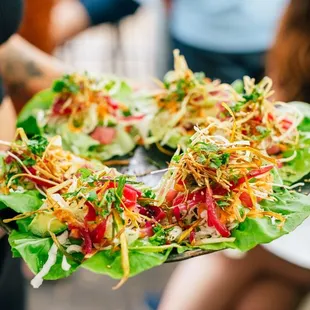 a person holding a plate of salad