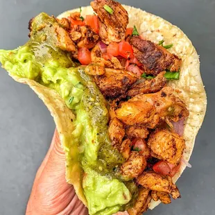 a hand holding a taco