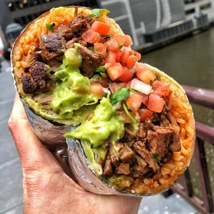 a hand holding a burrito