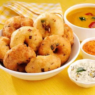 a bowl of fried doughnuts with dipping sauce
