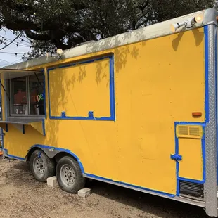 a yellow food truck with blue trim