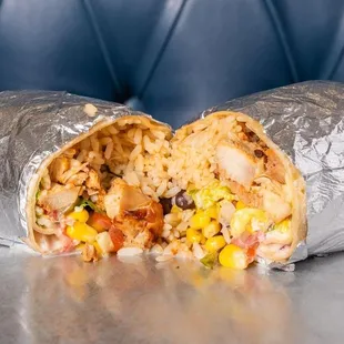 A hearty burrito packed with seasoned chicken, rice, corn, black beans, and fresh veggies, all wrapped up for a perfect, flavorful bite!