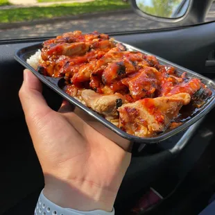 a person holding a tray of food