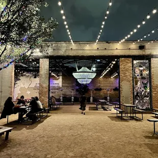 people sitting at tables under string lights