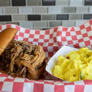 a pulled pork sandwich with macaroni and cheese