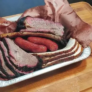a tray of meat and sausages