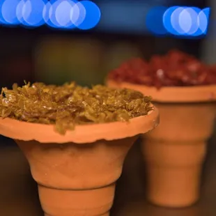 two flower pots filled with fruit