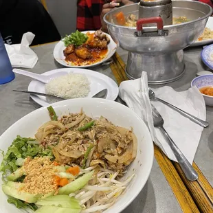 a woman sitting at a table with plates of food