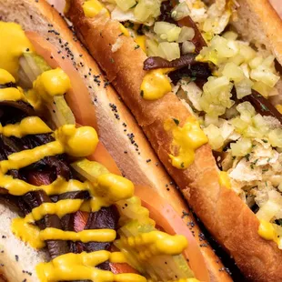 two hotdogs with mustard and onions