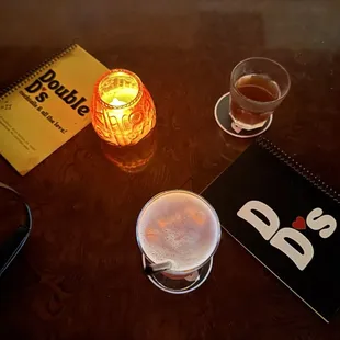two glasses of beer and a notebook on a table