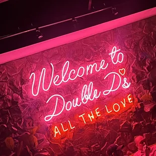 a neon sign that reads welcome to double d&apos;s all the love