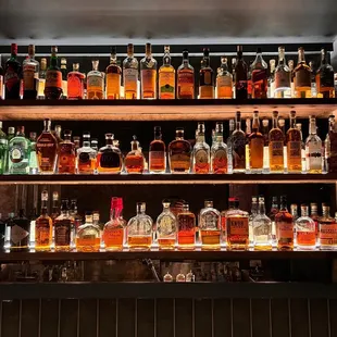 a shelf full of liquor bottles