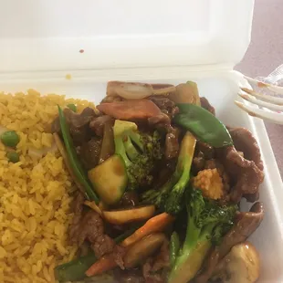 a styrofoam container with rice and vegetables