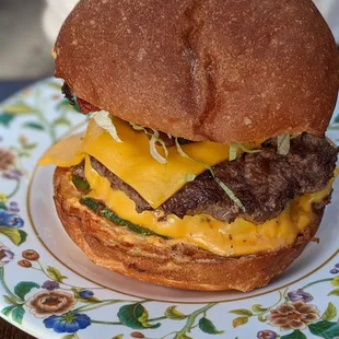 a hamburger with cheese and lettuce on a plate