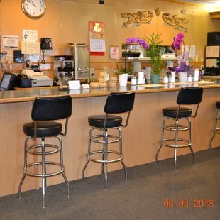 a bar with stools and a clock