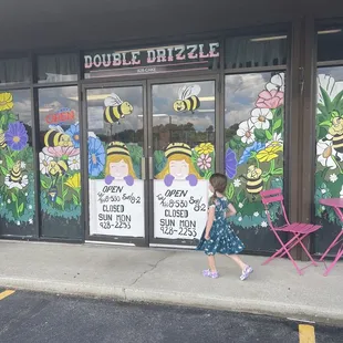 a little girl walking past a store