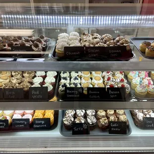 a variety of cupcakes in a display case