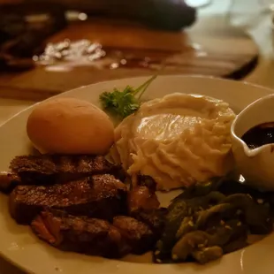 a plate of food with meat, mashed potatoes, and sauce