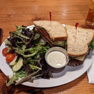 Turkey, cheddar, and bacon sandwich with a side salad