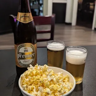 a bowl of popcorn and a bottle of beer