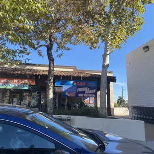 a blue car parked in front of a restaurant