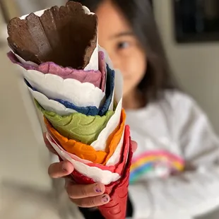a girl holding a cone of ice cream