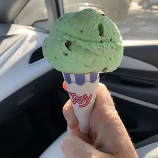 a hand holding a cone of ice cream
