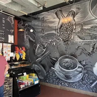  a man standing in front of a blackboard mural