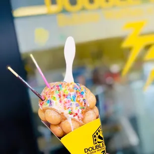 a person holding a cone of doughnuts