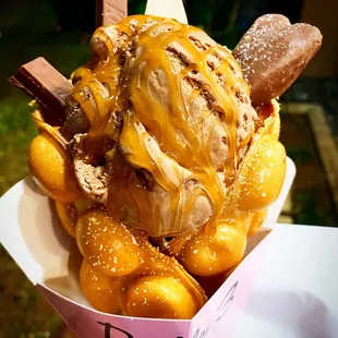 Vanilla bubble waffle cone with chocolate ice cream, caramel syrup, Kitkats &amp; a Reese&apos;s heart! Yikes!