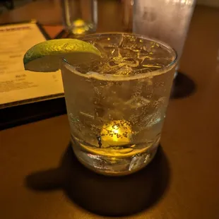 a drink in a glass with a lime wedge
