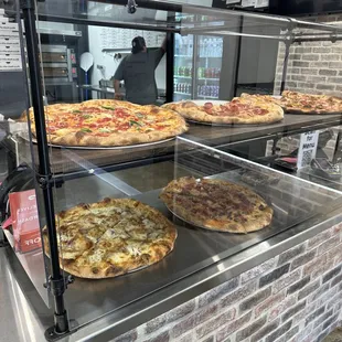 a variety of pizzas on display