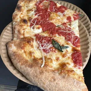 two slices of pizza on a paper plate