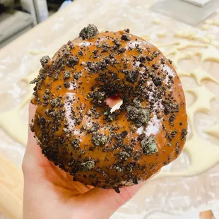 a hand holding a doughnut covered in sprinkles