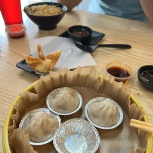 a bowl of dumplings and dipping sauces