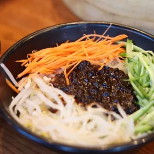 Zha Jiang Mian--Noodles set aside with dishes include veggies and freshly made bean paste sauce, mix after your liking.