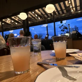 a table with two glasses of water and a plate of food