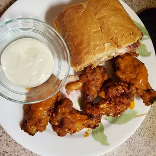 a plate of chicken wings and dip