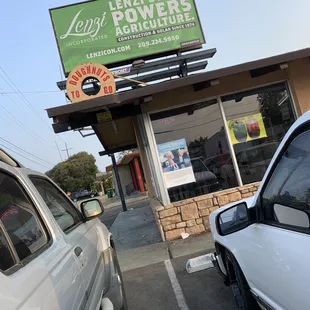 two cars parked in front of a store