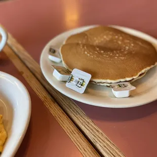 a plate of pancakes and a bowl of macaroni and cheese